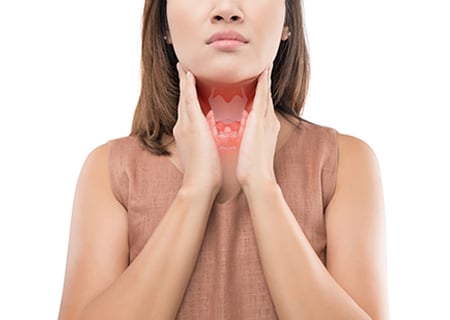 Woman holding her neck with highlighted thyroid gland illustration showing thyroid health concept
